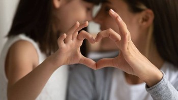 Mother and Daughter making heart shape with hands